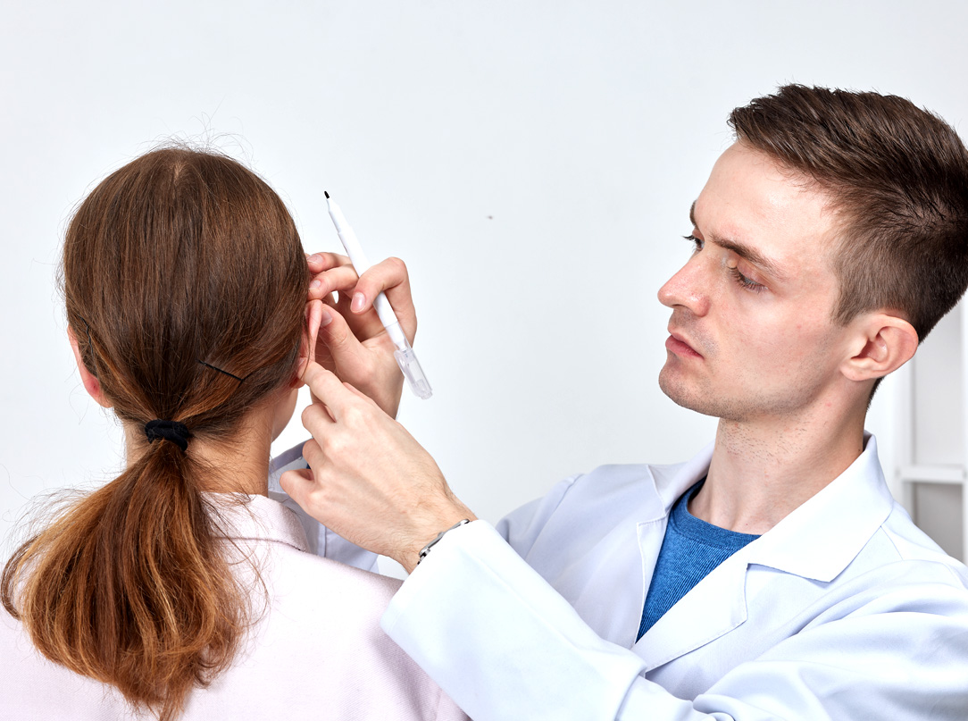 Zdjęcie przedstawia zabieg otoplastyki - chirurgii uszu który poprawia wygląd uszu, modelując je w sposób, który przywraca równowagę i harmonię twarzy.